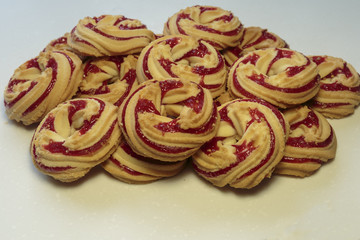 Shortbread cookies with strawberry jam on white background close-up.