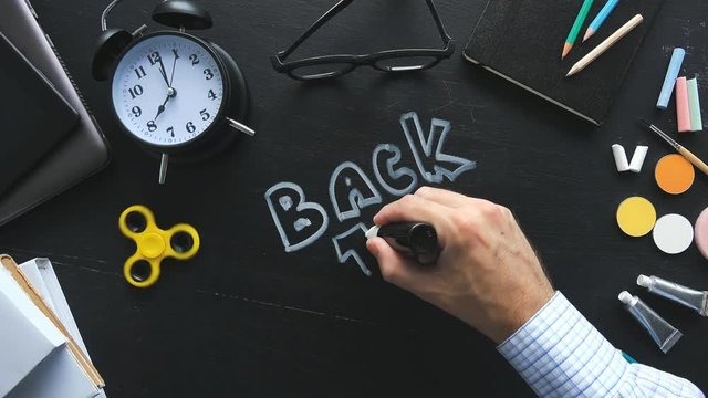 Teacher writing Back to School on classroom chalkboard, new semester is starting