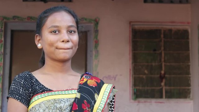 Mid shot of a young beautiful pretty Indian woman laughing and smiling with happiness and joy and looking at someone at the peaceful location and safety of her home static shot 