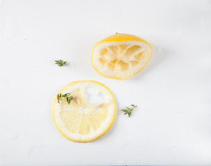 Top view of a slice of lemon and squeezed lemon on a white background