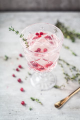 Glass with patterns with lemonade from cranberry, thyme and with a spoon