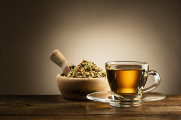 glass cup of tea with herbal tea on wooden table