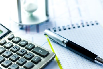 Hourglass and Calculator on Business Graphs and Charts