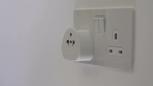Man inserts plug into socket with adapter