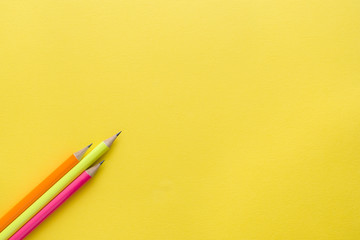 Bright colored pencils on yellow background. Copy space