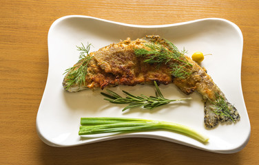 Fried rainbow trout with vegetables and greens