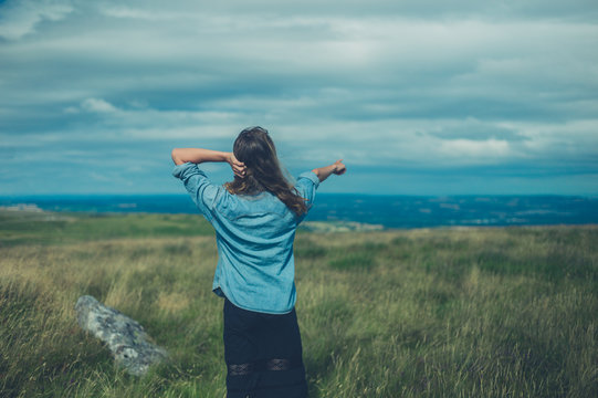 Woman on hilltop is pointing