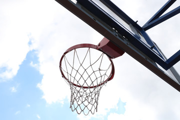 Basketball Hoop on a street basketball court on the background of blue sky in the clouds