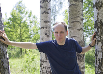 man near a birch in sunny day