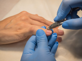 Trimming of the cuticles in a beauty salon. Close up.