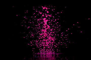 Magenta, pink  paint, ink splash on black background