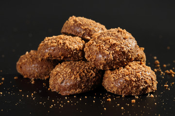 Close up of a pile of delicious crunchy caramel biscuits coated with milk chocolate and biscuit particles