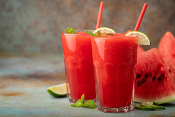 Watermelon slushie with lime, summer refreshing drink in tall glasses on a blue rusty background. with copy space