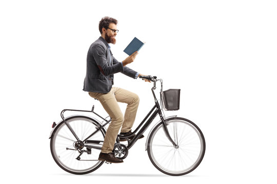 Young man riding a bicycle and reading a book