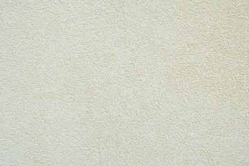 background wall with off-white or pale yellow roughcast plaster texture