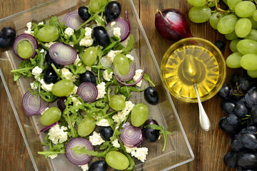 Salad with various grapes, goat cheese, purple onion, arugula, top view