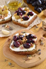 Crostini with roasted grapes, goat cheese, walnuts and honey, vertical