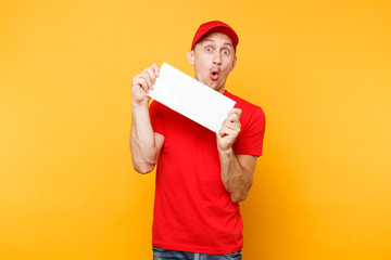 Delivery man in red uniform isolated on yellow orange background. Professional male employee courier in cap, t-shirt hold white empty blank paper. Service concept. Copy space place for text or image.