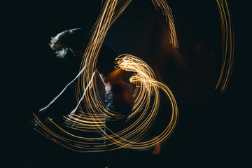 Lights dancer in the dark. Top naked man dynamic movement. Long exposure creative portrait....