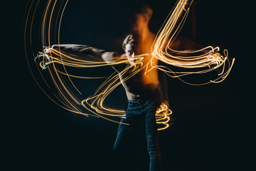 Lights dancer in the dark. Top naked man dynamic movement. Long exposure creative portrait....