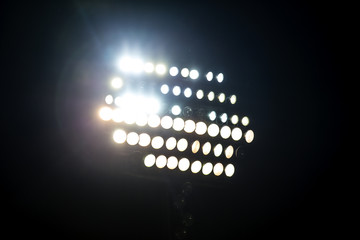 Light tower reflectors at a stadium during nightime.