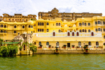 Obraz na płótnie Canvas View from Lake Pichola onto yellow platial buildings in Udaipur, India