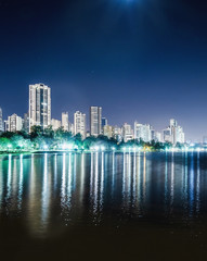 Obraz premium Pionowe zdjęcie Lago Igapo, Londrina - Parana, Brazylia. Widok na jezioro Igapo nocą i miasto, budynki w tle. Miejsce wypoczynku, turystyczne przeznaczenie miasta.