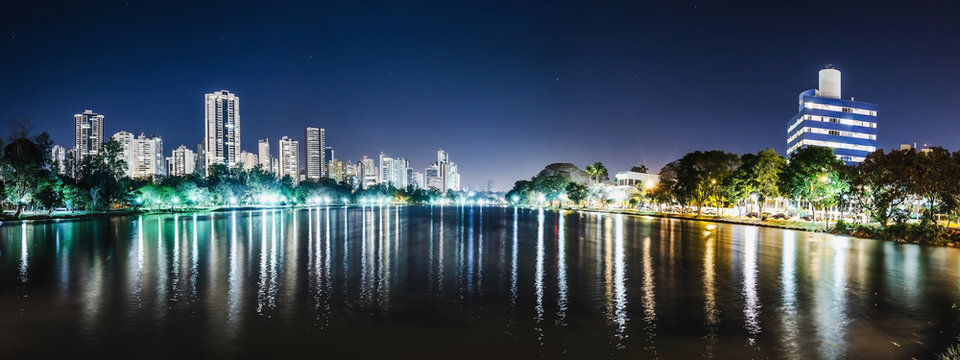 Panoramic photo of the Lago Igapo, Londrina - Parana, Brazil. View of the Igapo lake at night and the city, buildings on background. Leisure place, touristic destination of the city.