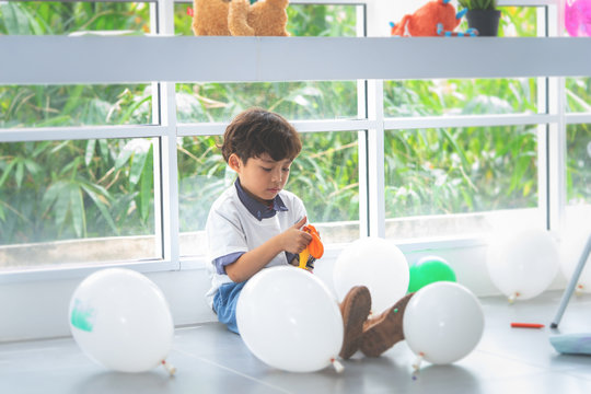 Boy Is Blowing Ballon With Tool For Party