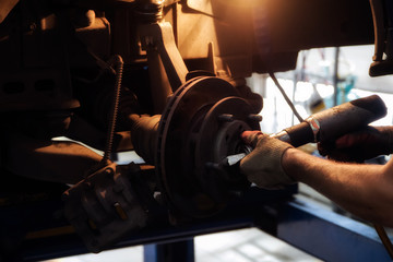 car garage auto mechanic repairman tighten screw with spanner during automobile maintenance at repair service station