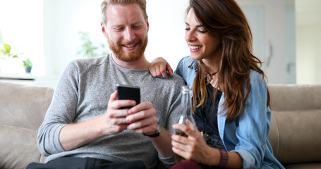 Relaxed couple or friends using mobile phone together to shop online