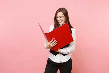 Young laughing joyful successful business woman in glasses looking on red folder for papers document isolated on pink background. Lady boss. Achievement career wealth. Copy space for advertisement.