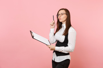 Young puzzled beautiful business woman in glasses holding clipboard tablet with papers document isolated on pink background. Lady boss. Achievement career wealth concept. Copy space for advertisement.