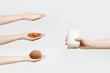Set of close up female hands hold milk in glass, exotic coco nut, almond, rice isolated on white background. Proper nutrition, vegan vegetarian drink, healthy lifestyle, dieting concept. Copy space.