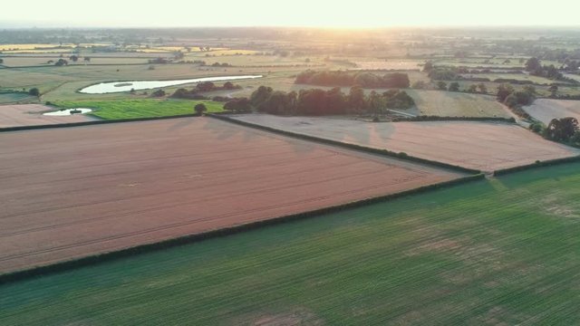 Aerial view, zoom out move. Beautiful sunset in cheshire, brown and green fields