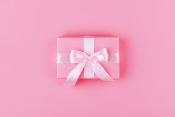 Gift or present box on pink table top view.