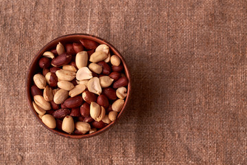 dry peanuts background. close up dry peanuts in clay bowl. Space for pext. Copyspace