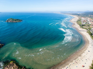  Aerial view of Brazilian beach with white sand, blue sea, and harbor.
