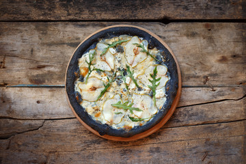 Top view black quattro formaggi pizza on wooden background with copy space. Menu, recipe or pizza delivery concept image