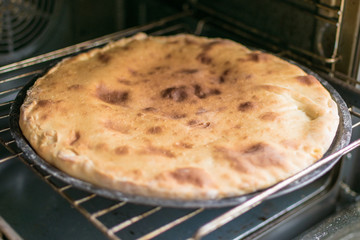 Pie with cheese, khachapuri in the oven.