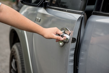 man hand opening a car door,Close up of a man opening a car door in a garage