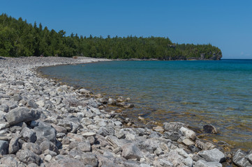 Fototapeta na wymiar Lake Huron shoreline blue green water and limestone rocks along the Georgian bay lake shore landscape