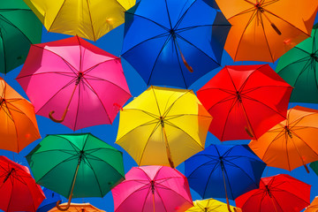 Fototapeta na wymiar Lots of colorful umbrellas in the sky. City decoration