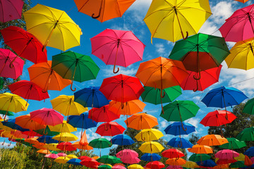 Lots of colorful umbrellas in the sky. City decoration - obrazy, fototapety, plakaty