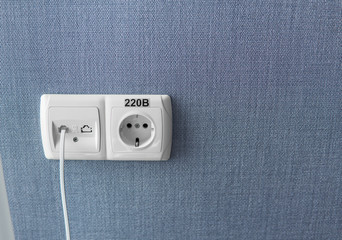 Socket on a blue wall, a multifunction outlet with an internet connection and european-style outlets
