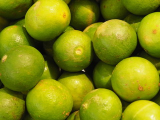 Colorful background of fresh picked, seasonal limes at market.