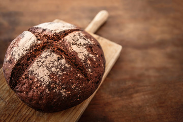 Fresh bread on wooden table. Top view with copy space. Rye Bread on cutting board closeup.