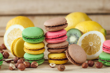 Green, pink, yellow and brown macarons with lemon, kiwi and hazelnuts