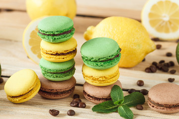 Green, yellow and brown macarons with kiwi coffee beans and mint decorations