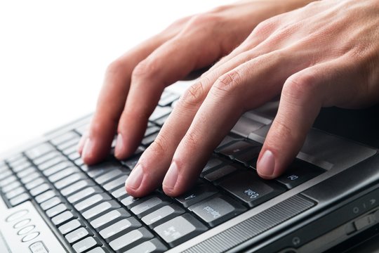 Closeup of a Person Typing on a Laptop Keyboard